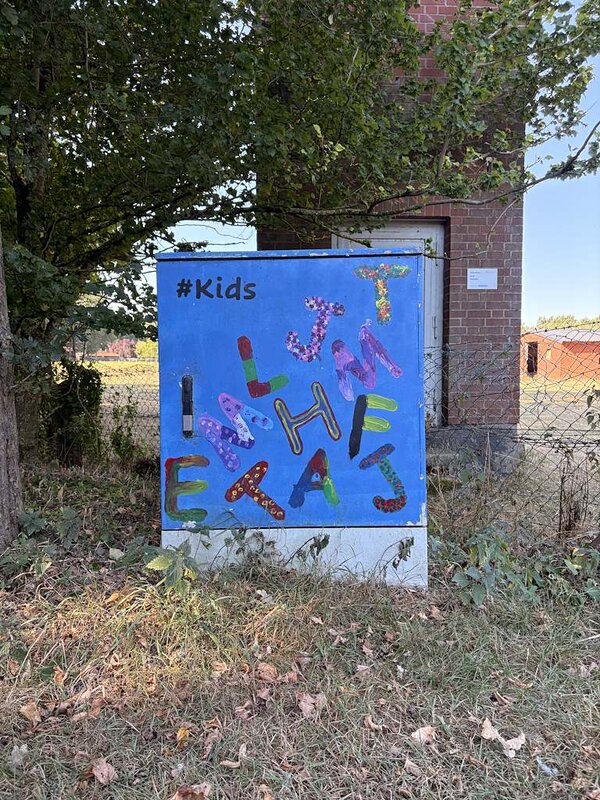 Ein Stromkasten, der mit Grafitti bemalt wurde und mehrere Buchstaben in verschiedenen Farben abbildet.