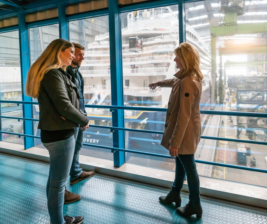 Bild von Meyer Werft - Personen stehen vor einem Schiff im Bau