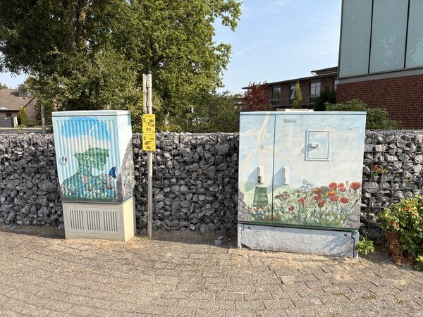Zwei Stromkästen, die mit Grafitti bemalt wurden.