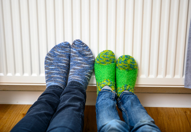 Blaue und grüne Socken lehnen an einer Heizung