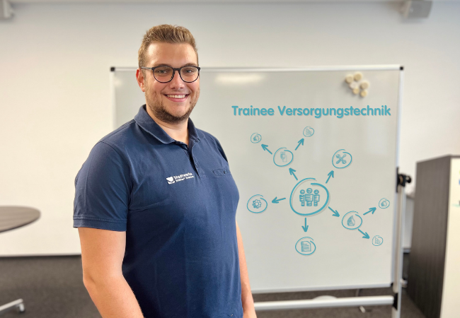 Junge mit blauem T-shirt steht vor einem Flipchart