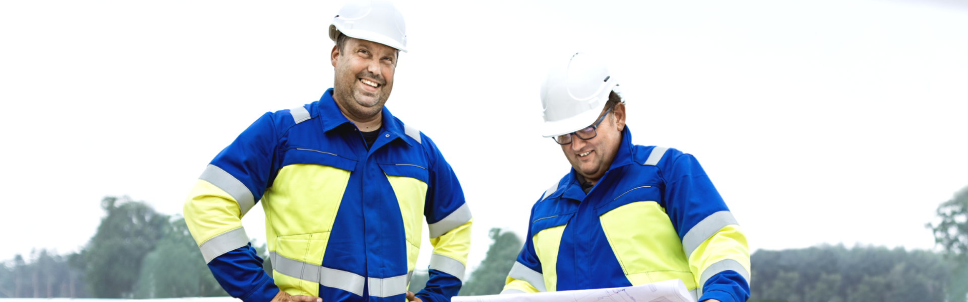 Zwei Männer in Monteurkleidung lachen
