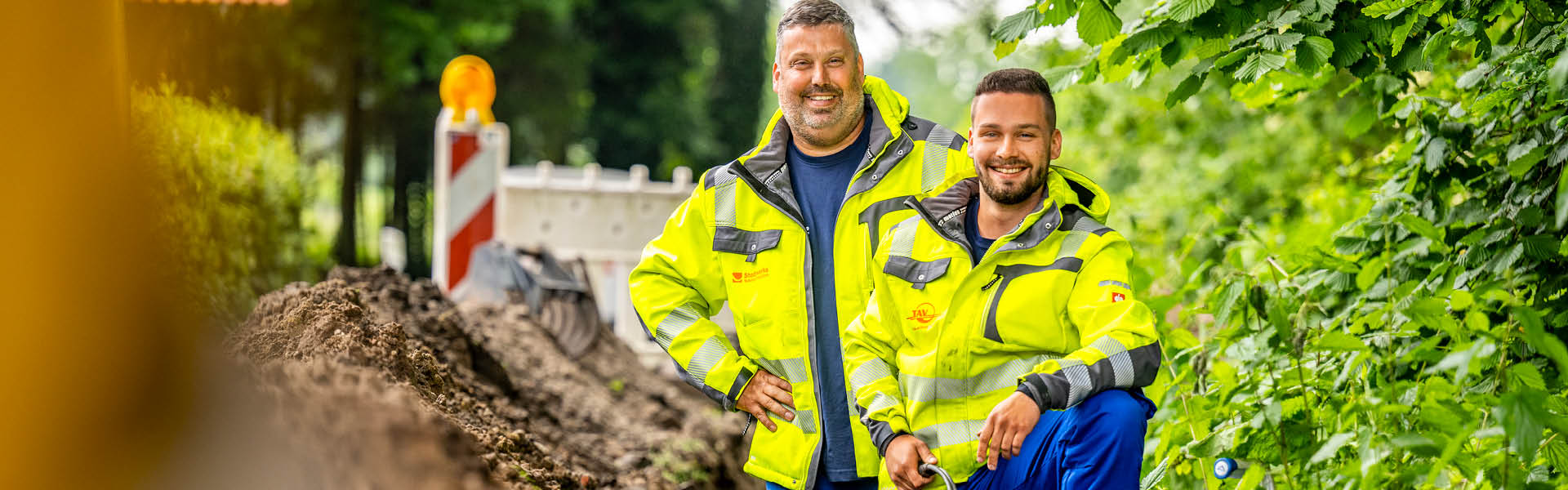 zwei Monteure stehen im Graben